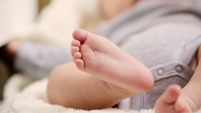 closeup of newborn laying on inclined baby sleeper